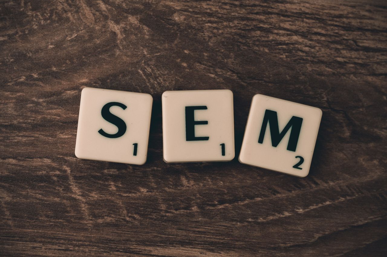 Home Wooden background with letter tiles spelling SEM, representing search engine marketing.